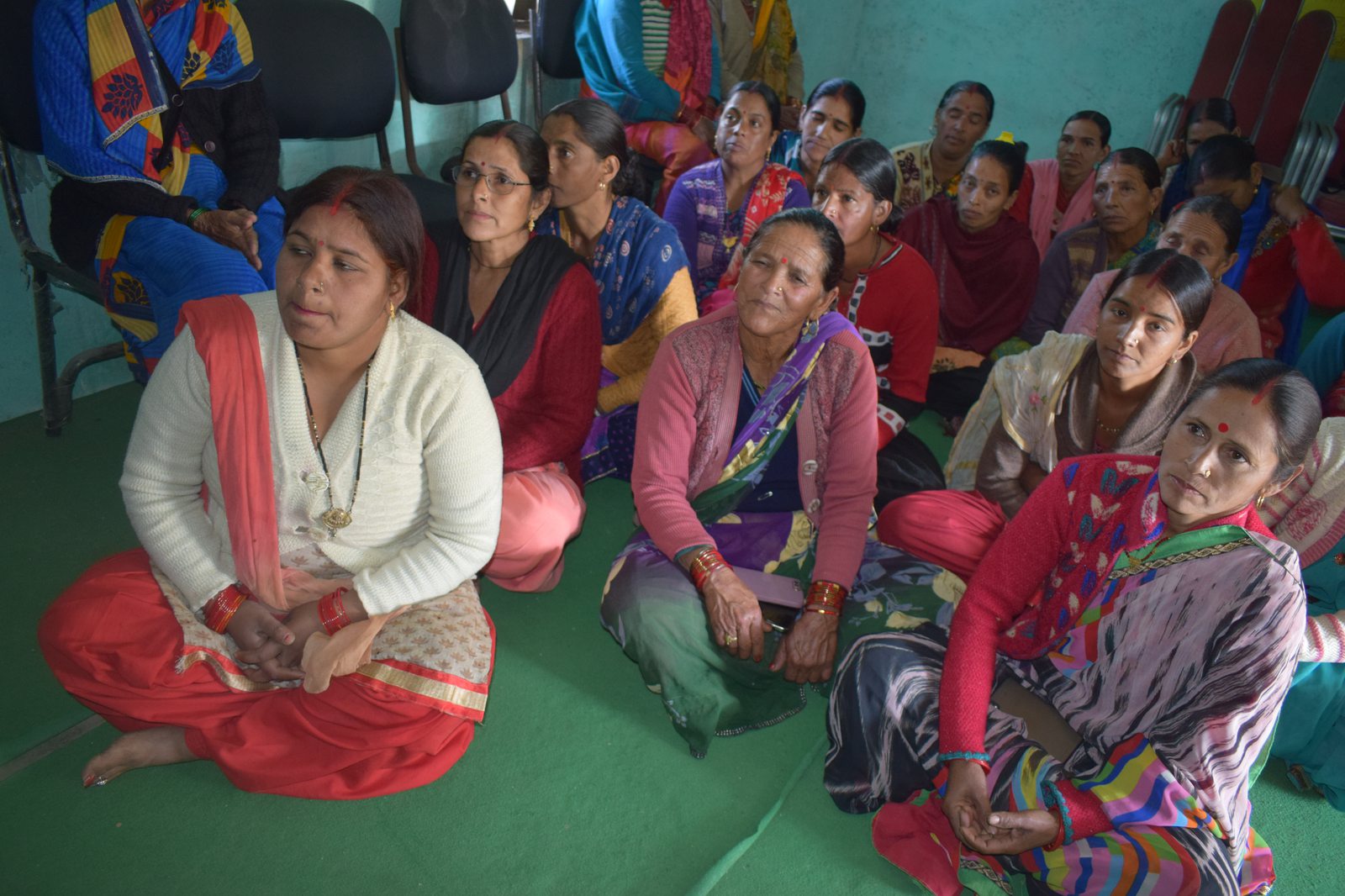 Women sitting attentively together in mutual support and community dialogue
