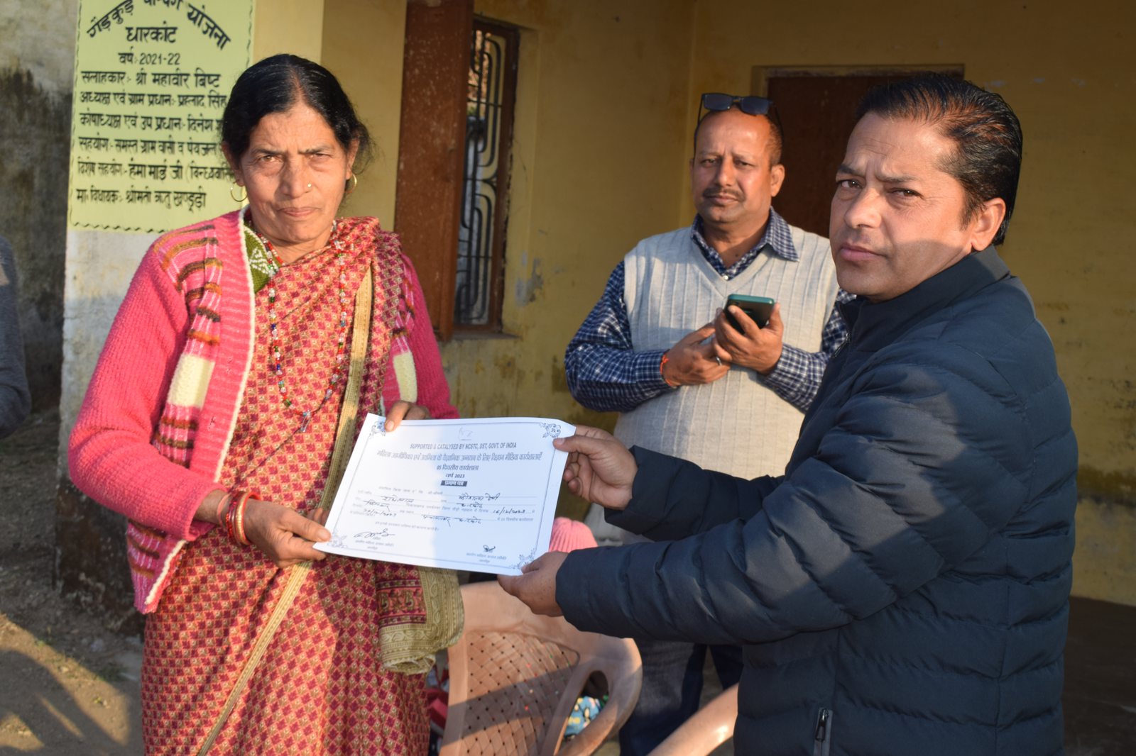 Woman leader receiving skill training certification from GMUS director