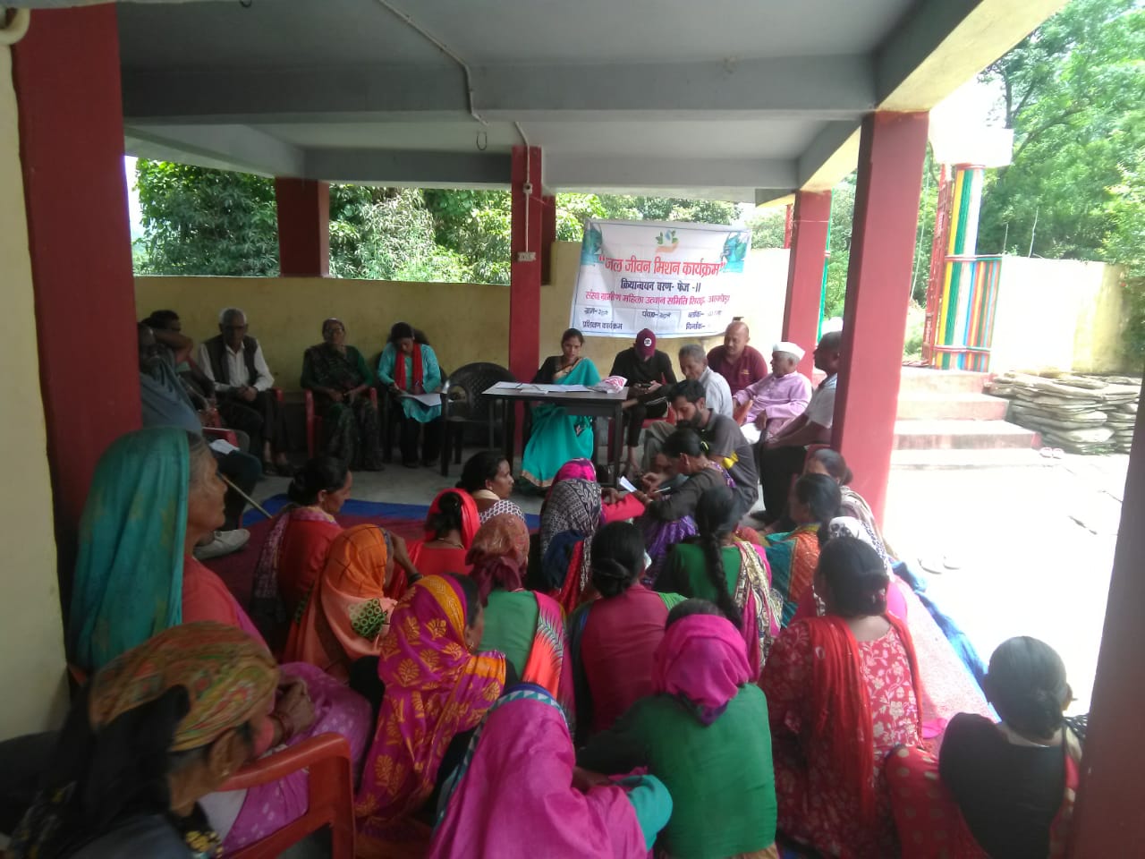 Women community members in a village porch consultation discussing water conservation